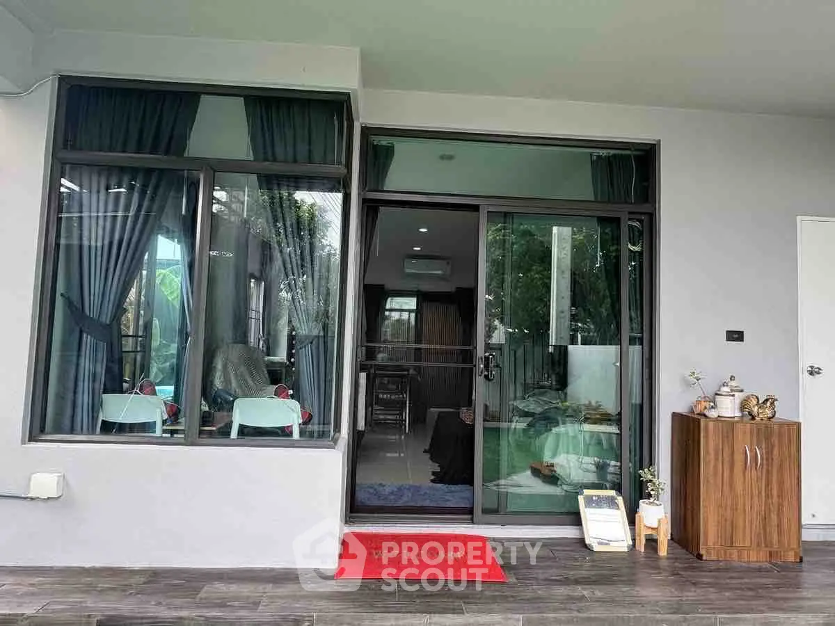 Charming modern home entrance with glass doors and cozy interior view.