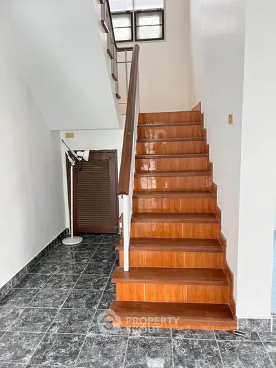 Stylish wooden staircase with modern design in a bright interior space.