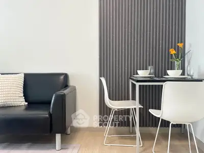 Modern living room with sleek black sofa and minimalist dining area