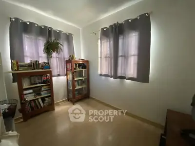 Cozy study room with bookshelves and natural light, perfect for reading and working from home.