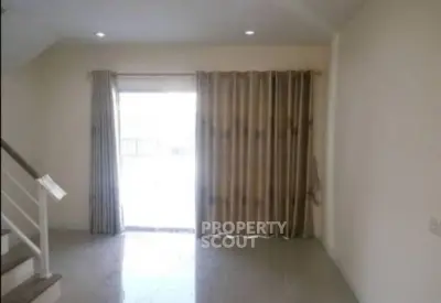 Spacious living room with natural light and modern staircase