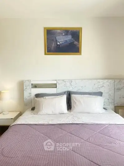 Elegant bedroom with marble headboard and cozy bedding, perfect for relaxation.