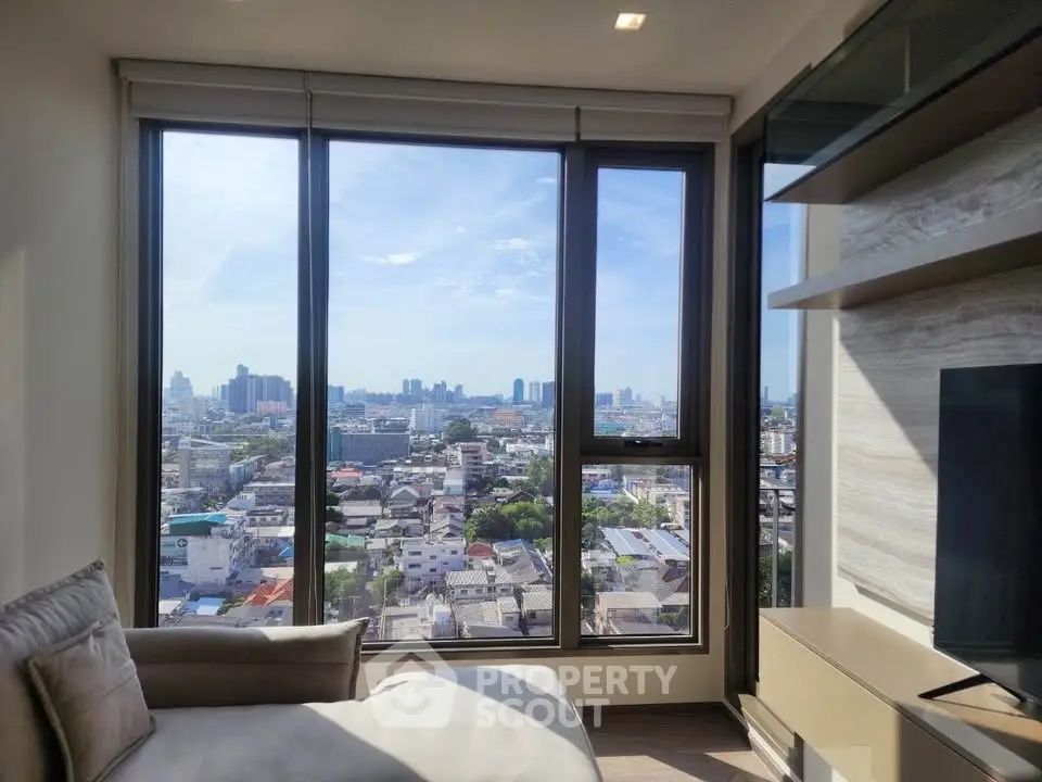 Stunning city view from modern living room with large windows and cozy seating.