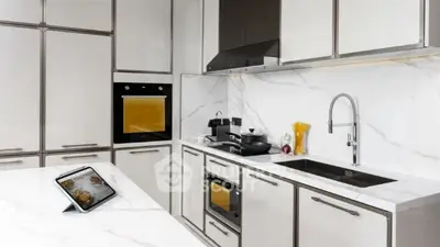 Modern kitchen with sleek white cabinetry and built-in appliances.