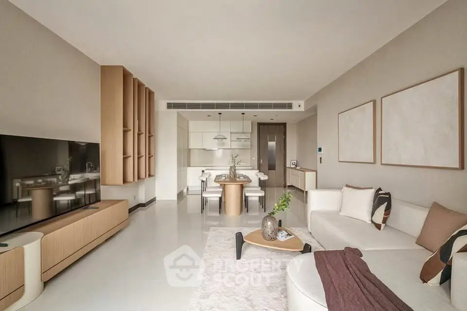 Modern living room with elegant furniture and open kitchen layout, featuring a large TV and stylish decor.