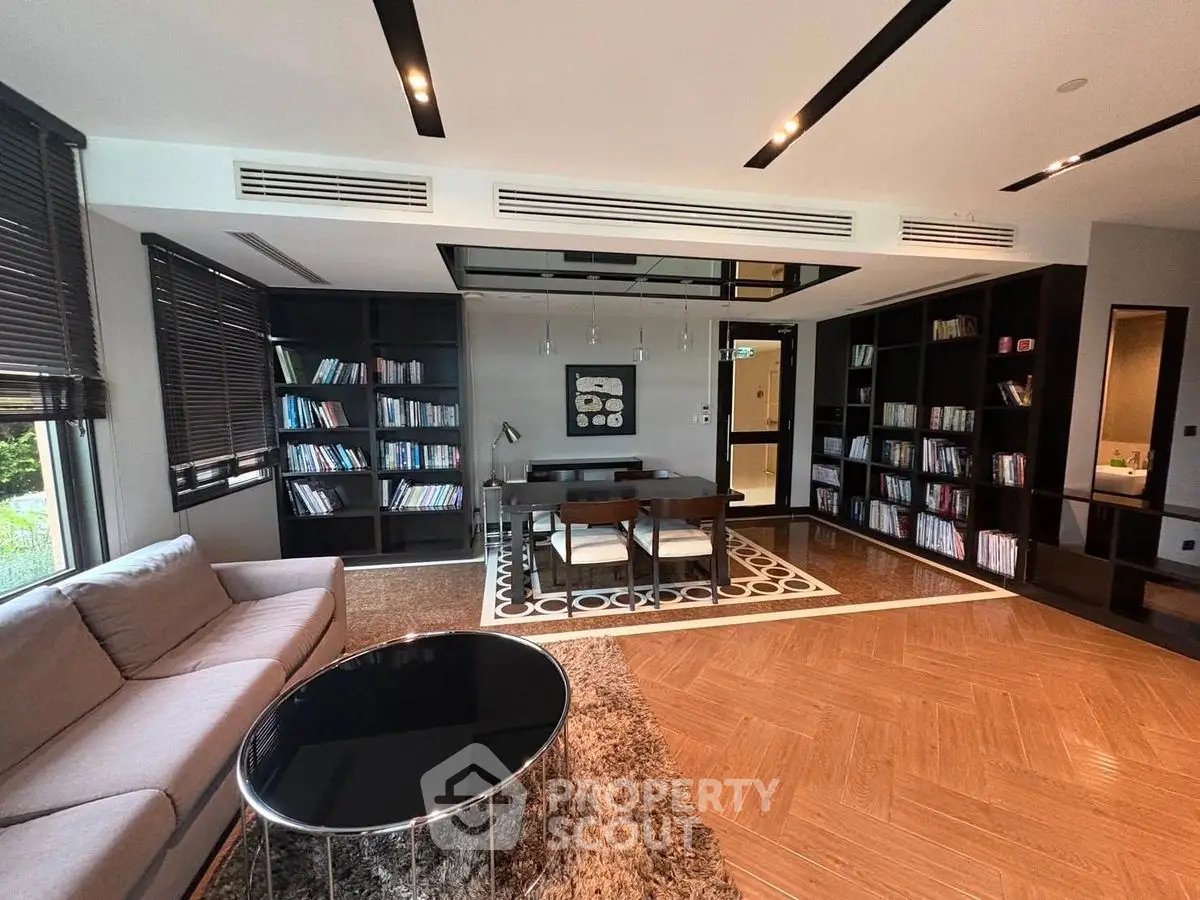 Luxurious modern living room with elegant decor and spacious layout, featuring a cozy seating area and stylish bookshelves.