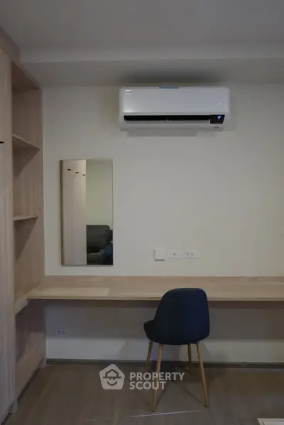 Modern study room with built-in desk, mirror, and air conditioning unit.