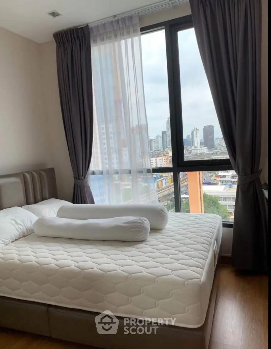 Cozy bedroom with city view and large window in modern apartment