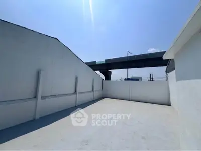 Spacious rooftop area with clear sky and urban view, ideal for outdoor activities or relaxation.