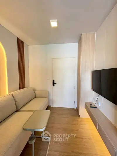 Modern living room with sleek design, featuring a cozy sofa and wall-mounted TV.