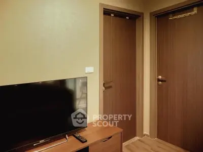 Modern living room with TV and wooden doors, perfect for cozy evenings.