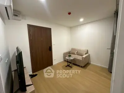 Cozy living room with modern decor and wooden flooring in a stylish apartment.