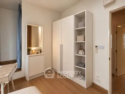 Modern bedroom with sleek white wardrobe and wooden flooring