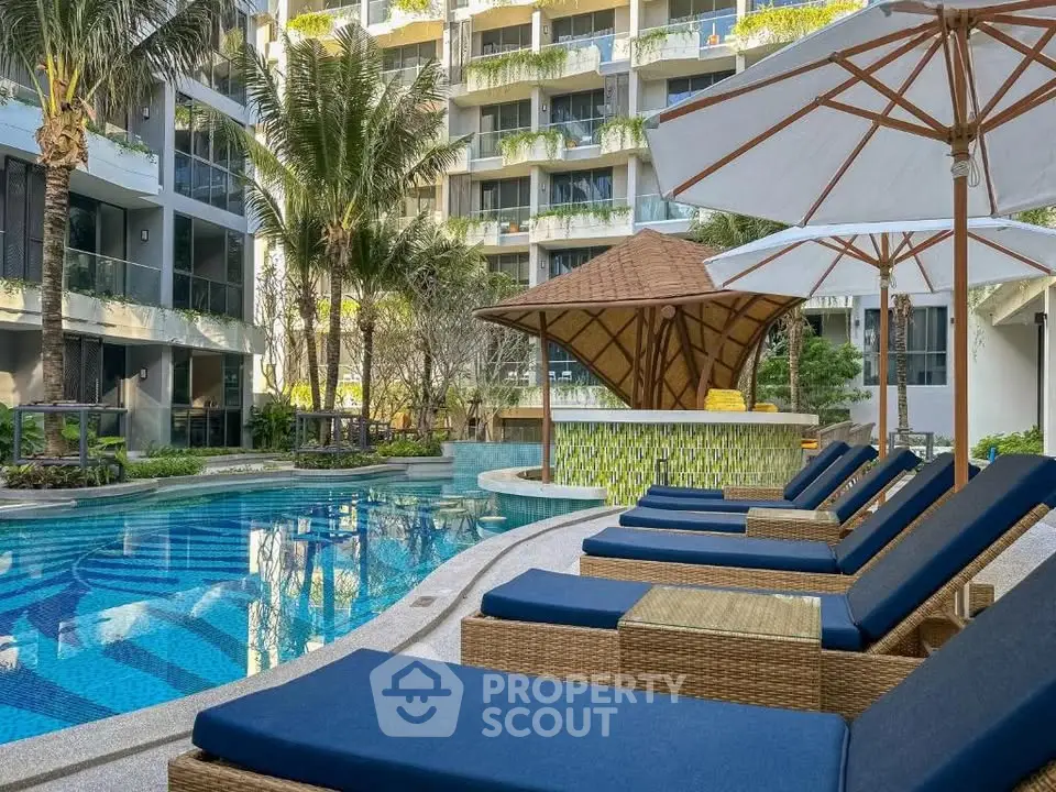 Luxurious poolside area with sun loungers and umbrellas in a modern residential complex.