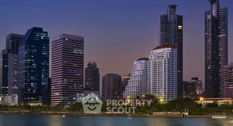 Stunning city skyline view with modern high-rise buildings by the waterfront at dusk.