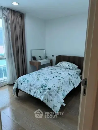 Cozy bedroom with single bed and natural light from large window