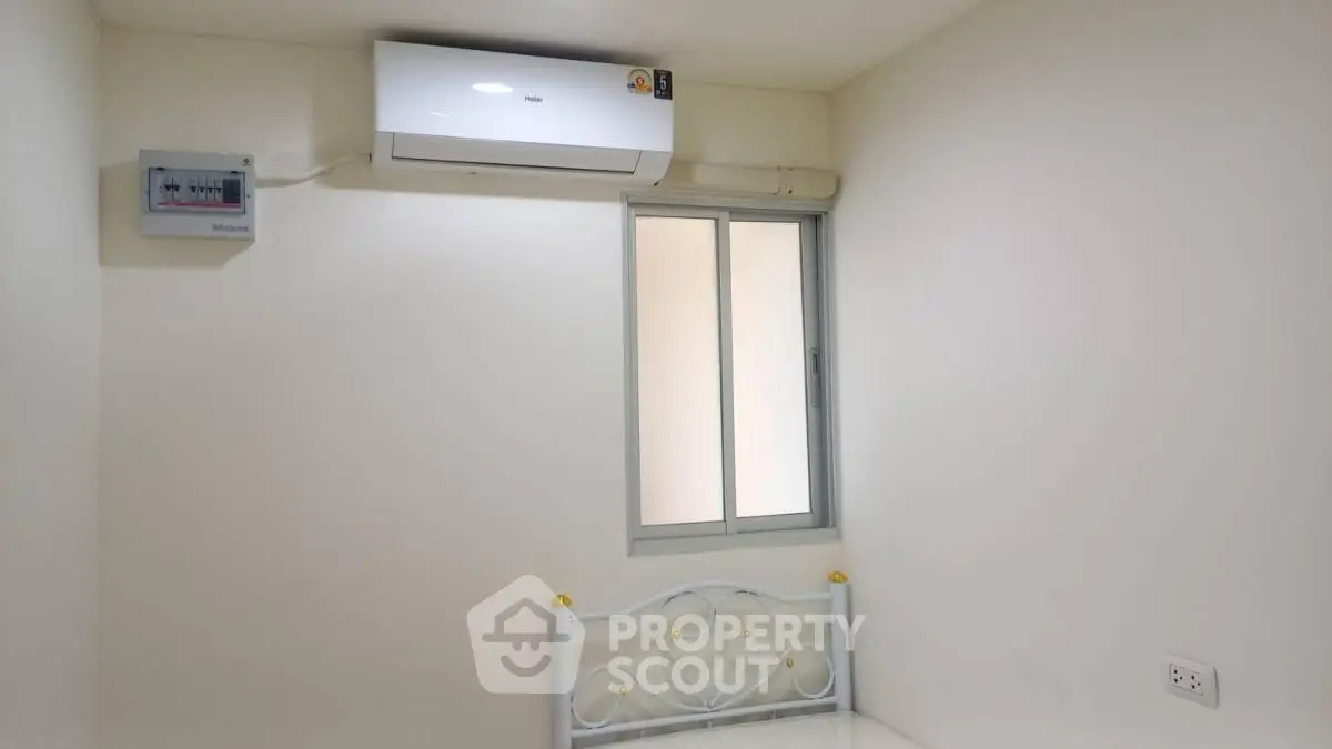 Minimalist bedroom with air conditioning and window, perfect for cozy living.