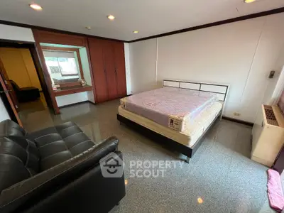 Spacious bedroom with modern furnishings and large window for natural light