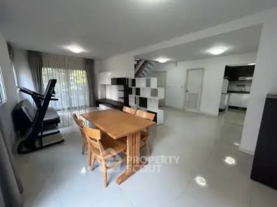 Spacious open-plan living and dining area with modern furnishings and natural light.