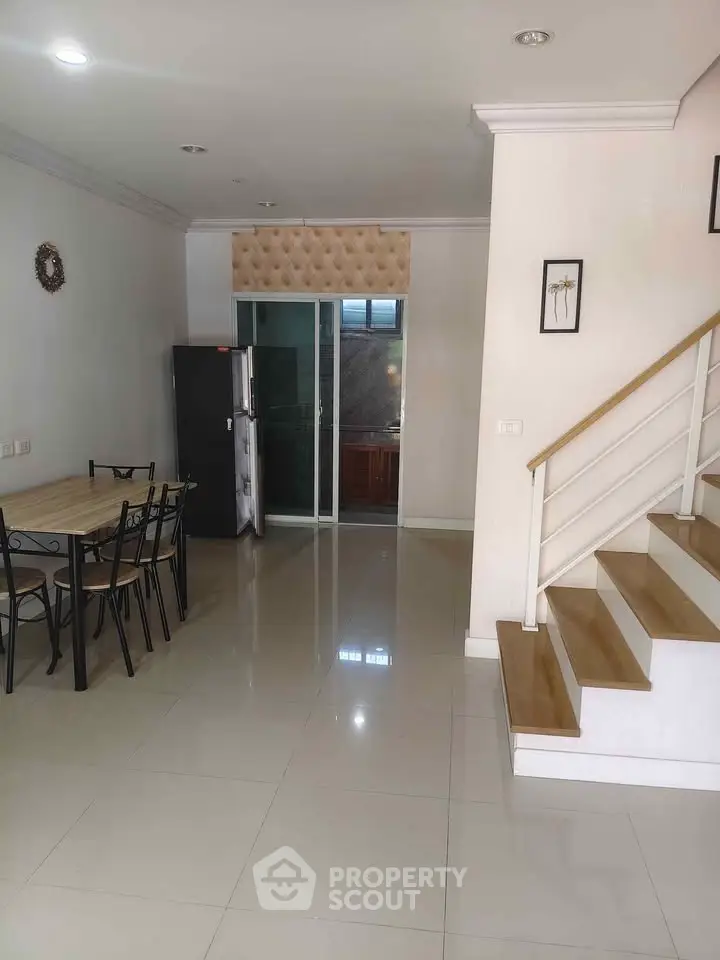 Spacious dining area with modern staircase and sleek kitchen access