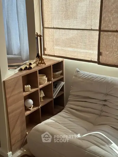Cozy living room corner with stylish shelving and comfortable seating, bathed in natural light.
