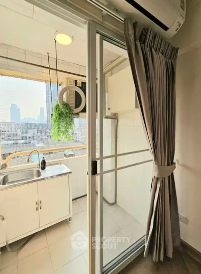 Charming balcony with city view, featuring a compact kitchen sink and modern air conditioning unit.