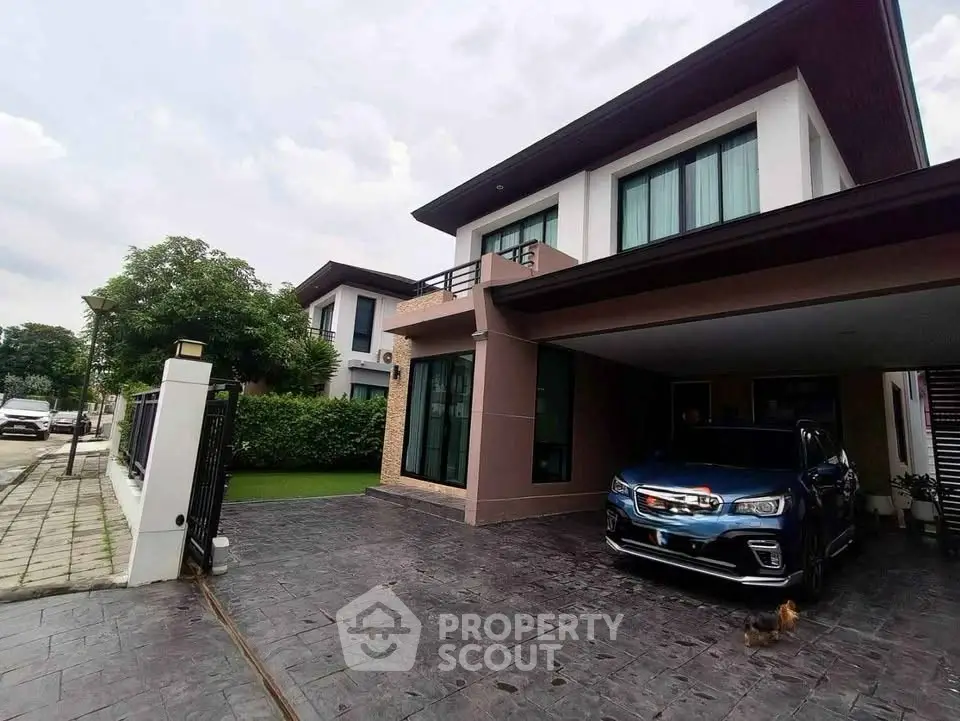 Modern two-story house with driveway and garage in a suburban neighborhood.