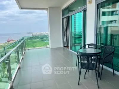 Spacious balcony with ocean view and modern outdoor seating.