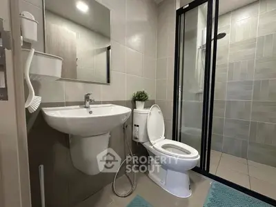 Modern bathroom with sleek fixtures and glass shower enclosure.