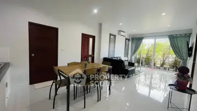 Modern living room with dining area and large windows opening to a balcony.