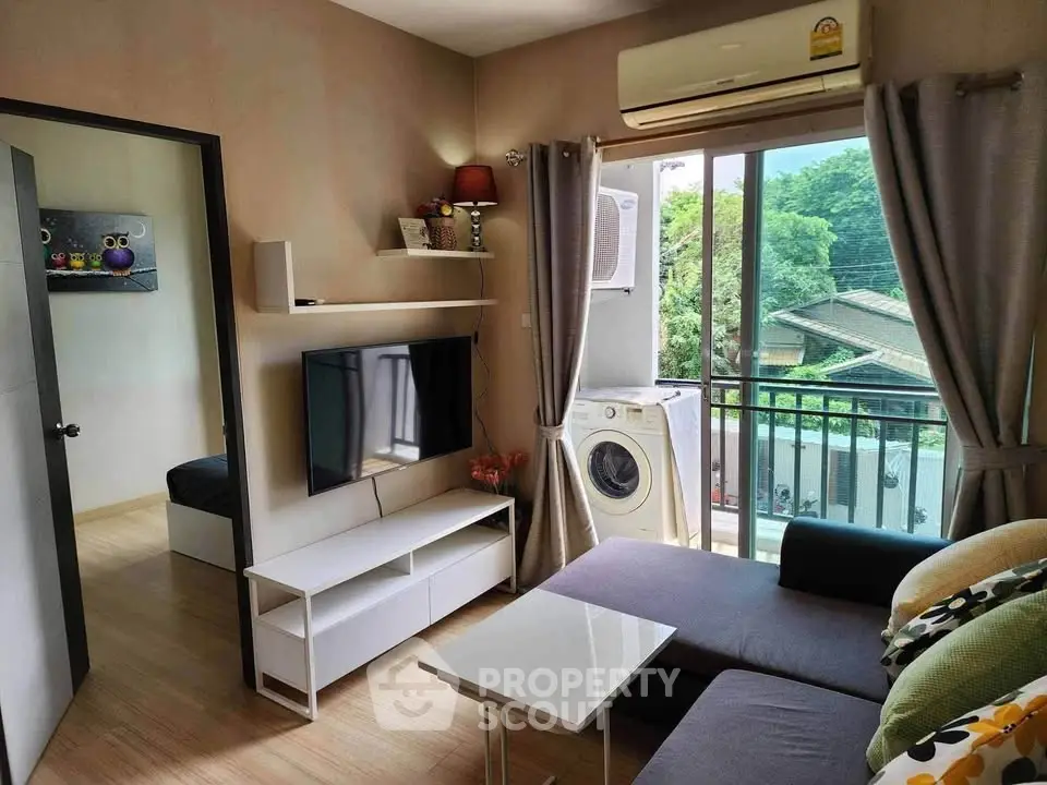 Modern living room with balcony view and washing machine, featuring sleek furniture and air conditioning.
