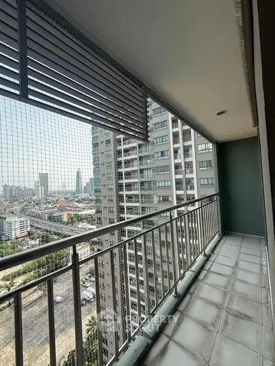 Spacious balcony with city skyline view in modern high-rise apartment.