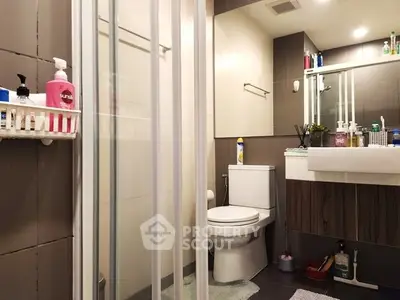 Modern bathroom with glass shower and sleek fixtures in contemporary apartment.