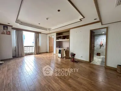 Spacious living room with wooden flooring and built-in shelves, perfect for modern living.