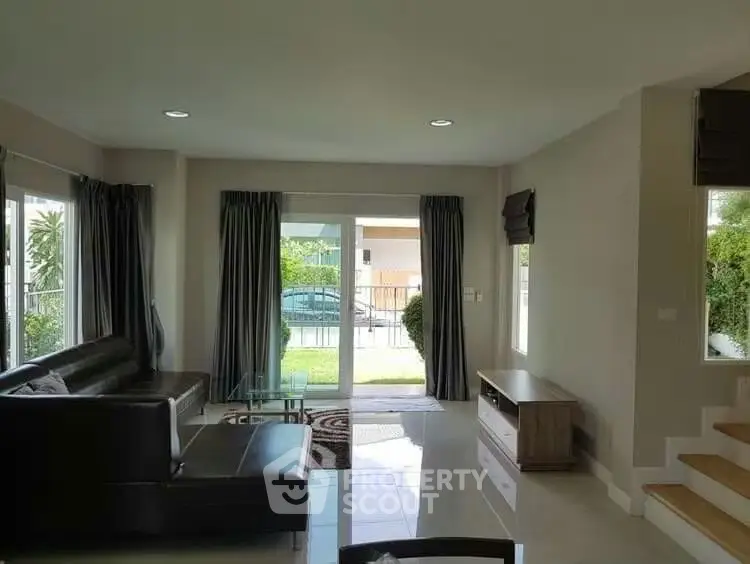 Spacious living room with modern furniture and garden view, perfect for relaxation and entertainment.
