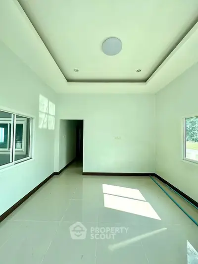 Spacious empty room with large windows and modern ceiling design
