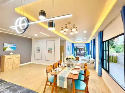 Stunning open-plan living and dining area with modern lighting and elegant decor.