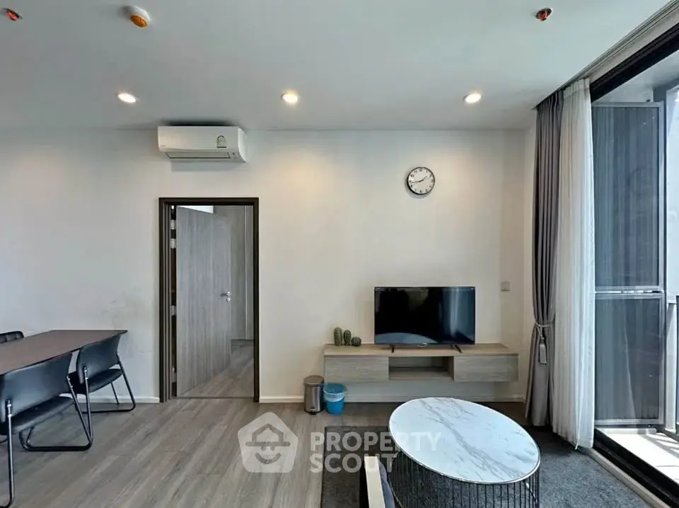 Modern living room with sleek furniture and balcony access in a stylish apartment.