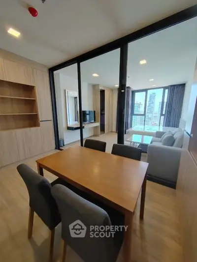 Modern open-plan living room with dining area and city view