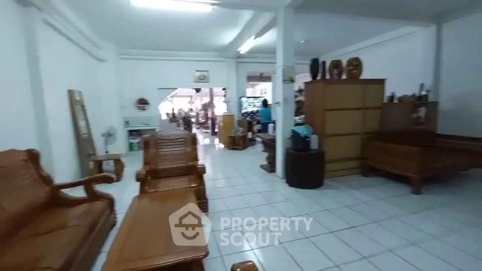 Spacious living room with wooden furniture and tiled flooring