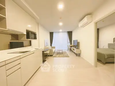 Modern open-plan living room and kitchen with sleek design and natural light