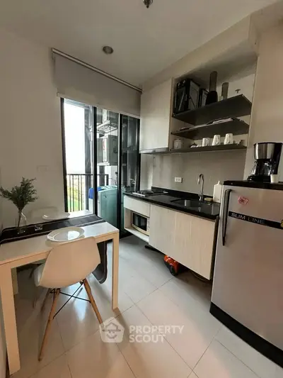 Modern compact kitchen with sleek appliances and dining area