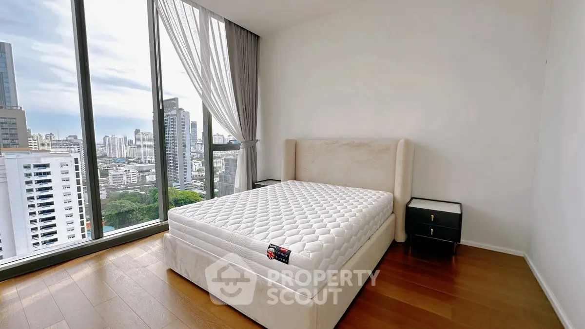 Modern bedroom with large windows offering stunning city views