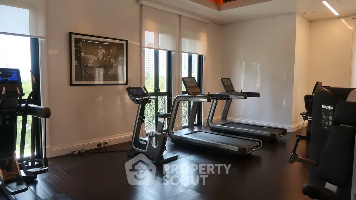 Luxurious gym with modern treadmills and large windows offering a scenic view, perfect for fitness enthusiasts.