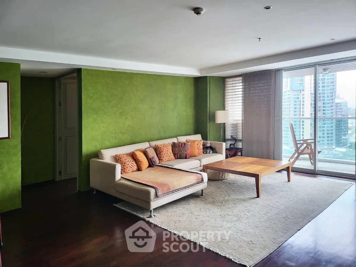Spacious living room with green accent wall and city view balcony
