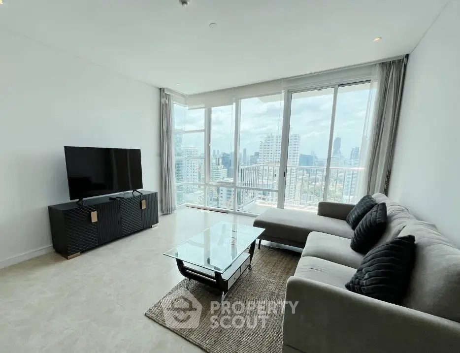 Spacious modern living room with panoramic city views and sleek furnishings.