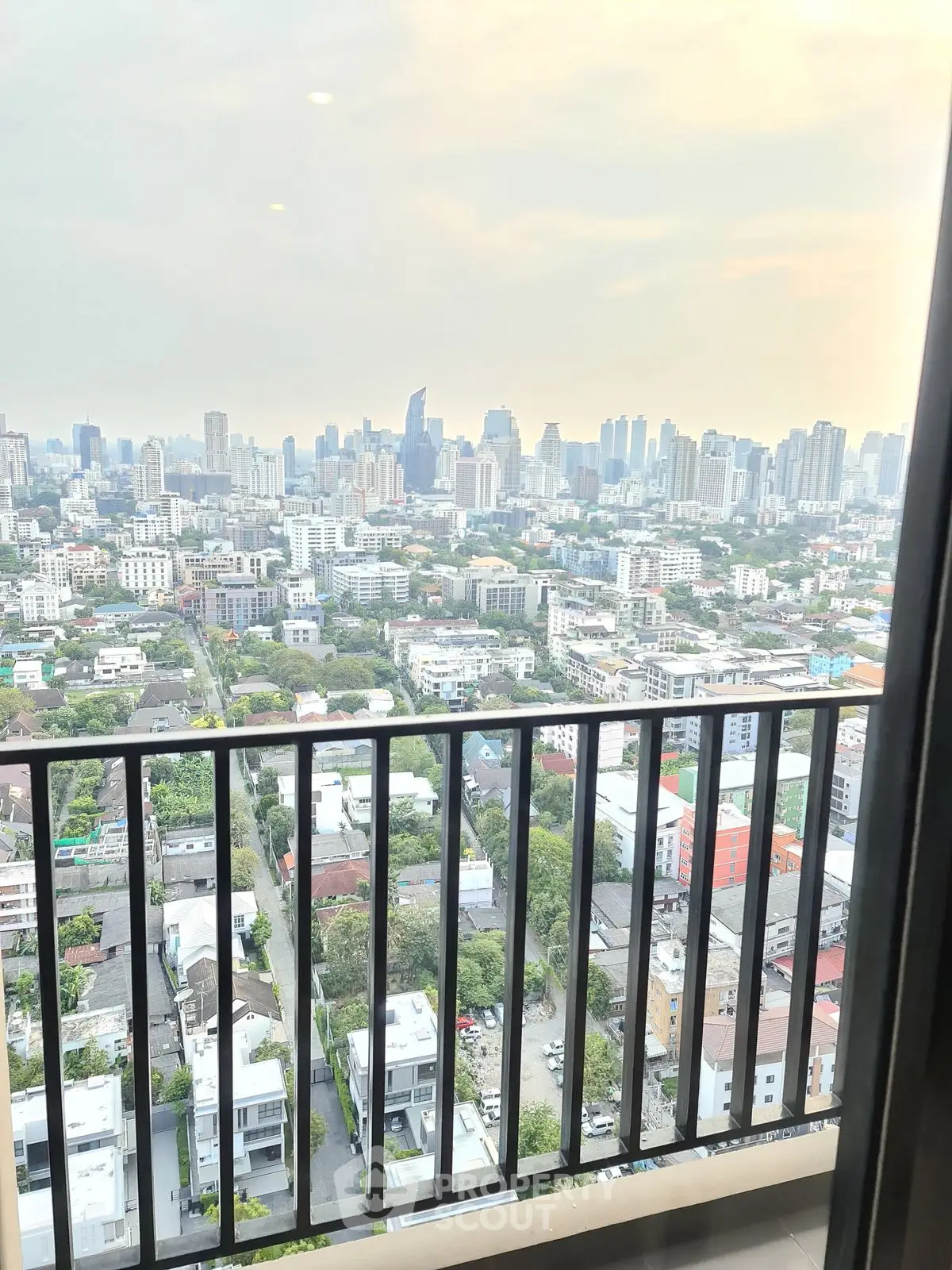 Stunning cityscape view from high-rise balcony overlooking urban skyline.
