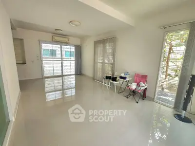 Spacious living room with large windows and glossy tiled floors, perfect for natural light and modern living.