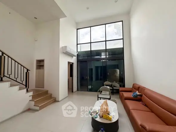 Spacious modern living room with high ceiling and large windows