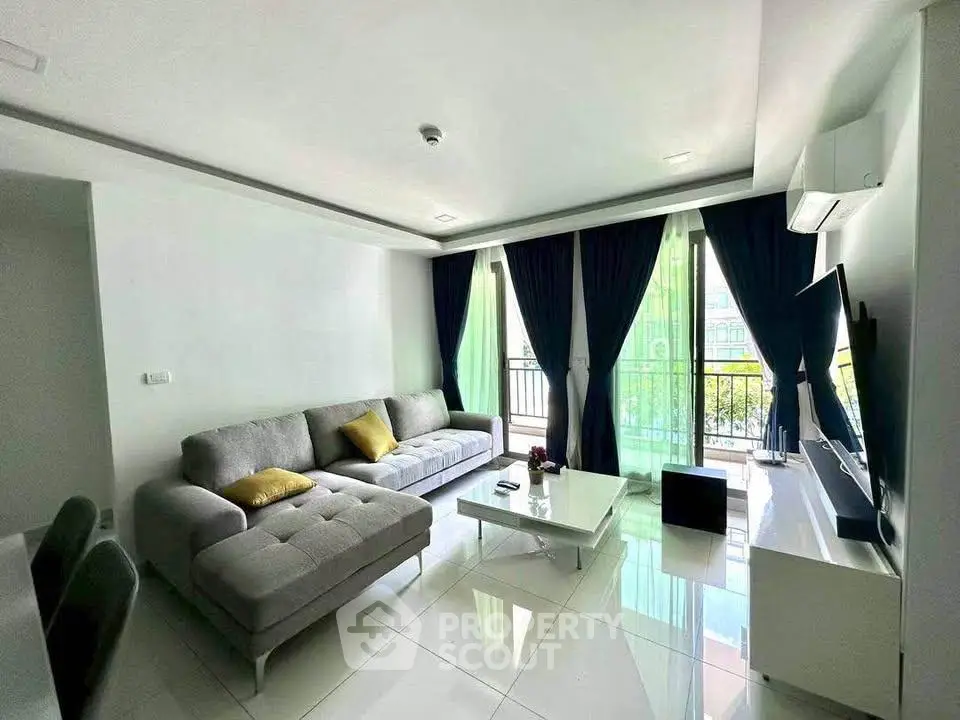 Modern living room with large windows and stylish furniture in a bright apartment.